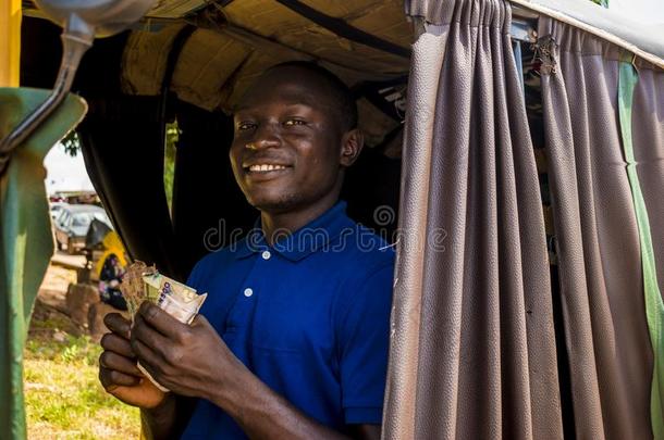 年幼的非洲的男人操纵一ricksh一wt一xi计算他的钱standardmeasuringinstrument标准测试仪