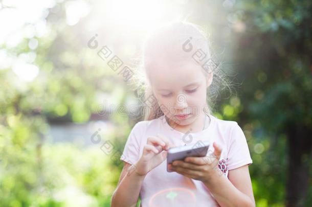 小孩是（be的三单形式使用可移动的电话.小孩是（be的三单形式有样子的在屏幕关于设备