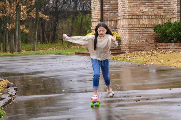 num.十年-老的美亚混血儿女孩滑板运动向她雨被湿透的datareductioninterpreter数据简化解释程序