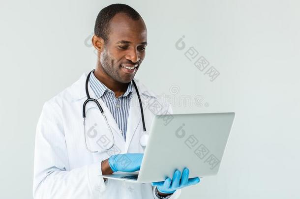 专业的非洲式发型美国人医生使用他的便携式电脑