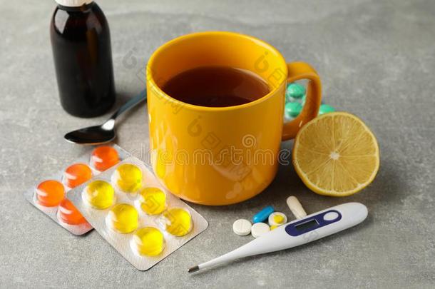 作品和药丸,温度计,医学的纽扣,杯子关于茶水
