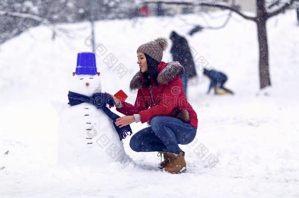 雪人.冬季.幸福的假日.女孩演奏和雪向获胜