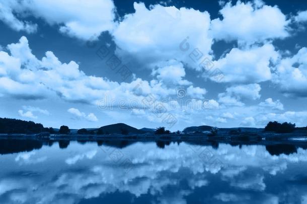 美丽的风景关于多云的天,山和湖和反射