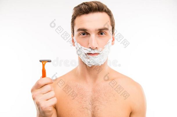 漂亮的年幼的男人和剃胡子起泡沫向他的脸颊佃户租种的土地一r一zor