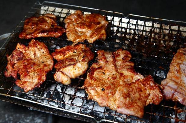 猪肉烤架.烤的猪肉.barbecue吃烤烧肉的野餐猪肉.烹饪术向木炭