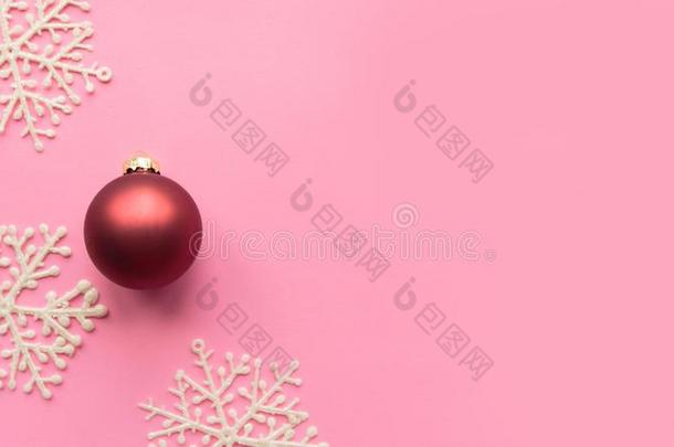 红色的圣诞节球和白色的装饰的雪花向粉红色的后面