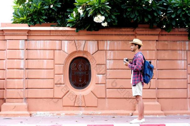 年幼的亚洲人男人旅行者背着背包徒步旅行的人佃户租种的土地照相机在期间茶苯海明