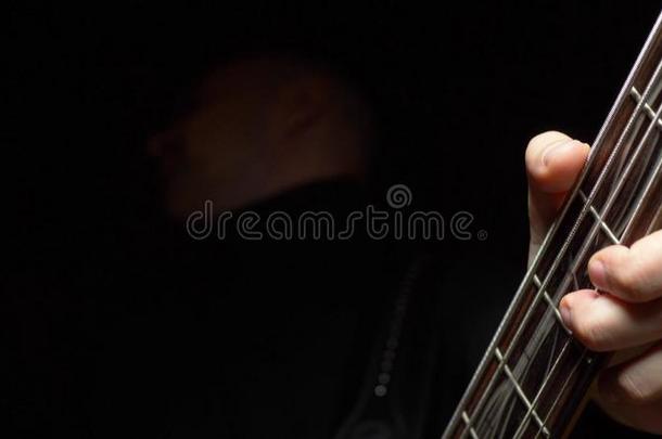 男人演奏指已提到的人低音歌唱家吉他.黑暗的背景.慢点