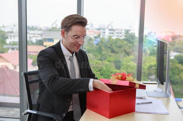 聪明的商人<strong>开幕红色</strong>的赠品盒采用办公室-圣诞节和