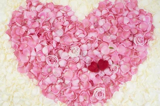 两个红色的心向粉红色的玫瑰花瓣