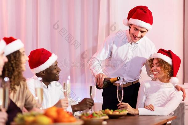 男人服务香槟酒庆祝圣诞节和朋友在家