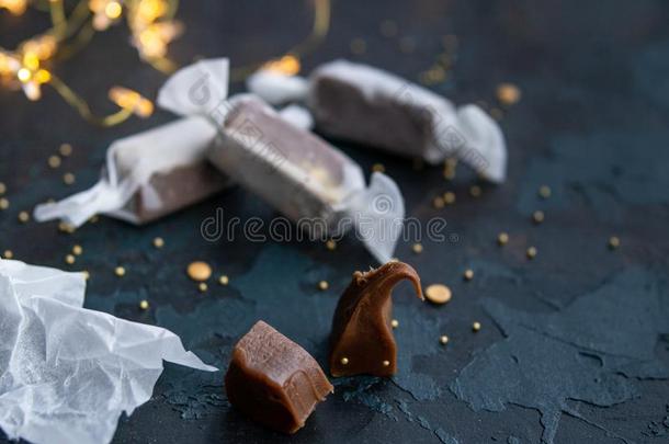 新鲜的金焦糖太妃糖结晶糖采用白色的纸向蓝色黑暗的波黑