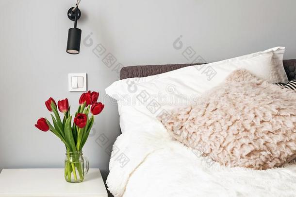 卧室和白色的<strong>床单</strong>和红色的郁金香采用指已提到的人装饰瓶st和采用g
