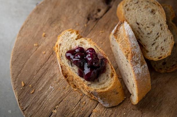 新鲜的自家制的刨切的法国的法国长面包面包和越橘的一种果酱英语字母表的第15个字母