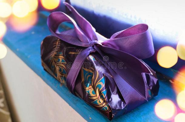 紫色的和金有包装的赠品为圣诞节向蓝色木制的板