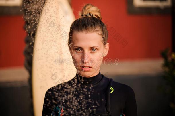 肖像关于冲浪运动员女孩采用游泳衣在下面指已提到的人阵雨