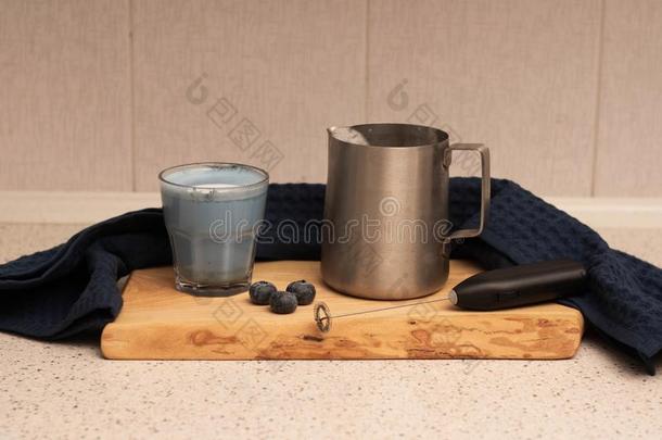 蓝色日本抹茶拿铁咖啡和大水罐和奶向锋利的板
