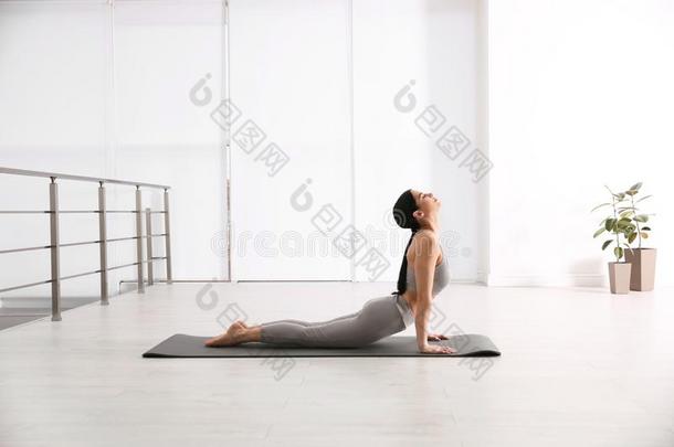 女人开业的眼镜蛇瑜珈的任何一种姿势采用瑜伽工作室.Bhujang瑜珈的任何一种姿势使摆姿势