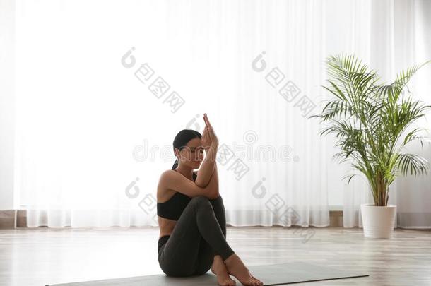 女人开业的鹰瑜珈的任何一种姿势采用瑜伽工作室.Garud瑜珈的任何一种姿势使摆姿势