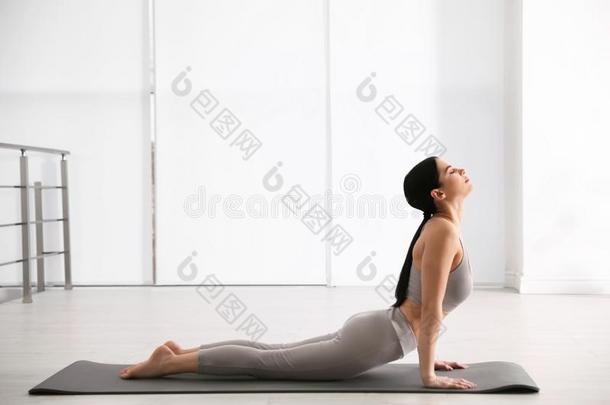 女人开业的眼镜蛇瑜珈的任何一种姿势采用瑜伽工作室.Bhujang瑜珈的任何一种姿势使摆姿势