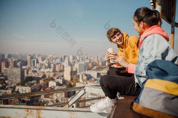 幸福的男朋友有样子的在女朋友所有午餐向屋顶