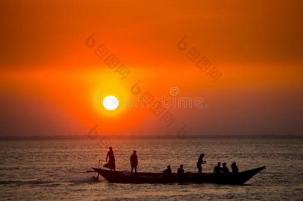 富有色彩的金色的日落向海.渔夫是返回家机智