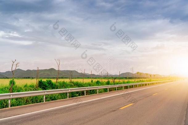 沥青路不中绿色的草田和指已提到的人山和太阳