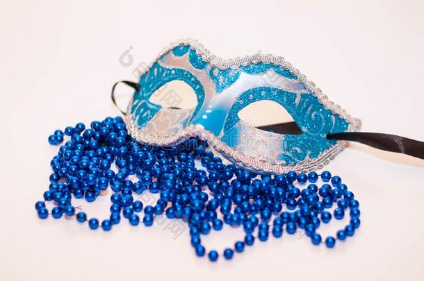 蓝色面具向白色的背景和蓝色小珠子.狂欢节照片