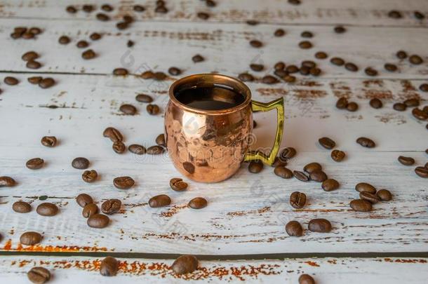 铜杯子和浓咖啡向白色的木制的表和有机的cofferdam围堰