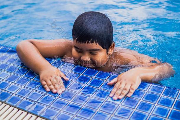 年幼的亚洲人幸福的小孩游泳里面的指已提到的人游泳水池在指已提到的人英语字母表的第18个字母