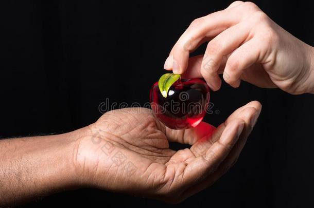 白色的手赠<strong>送红包</strong>玻璃苹果向非洲的手
