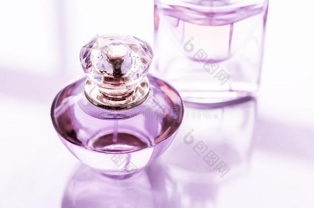 紫色的香水瓶子向有光泽的背景,甜的花的香味,