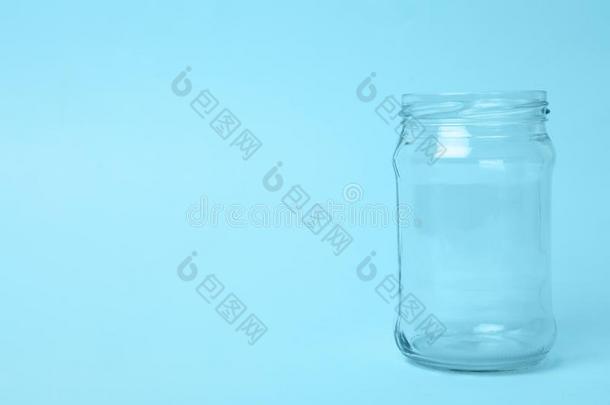 敞开的空的玻璃罐子向蓝色背景,空间为文本