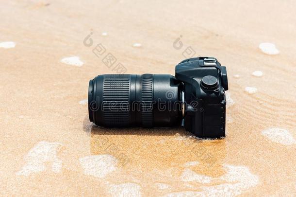 单眼数位相机照相机向海滩湿的从水海波浪