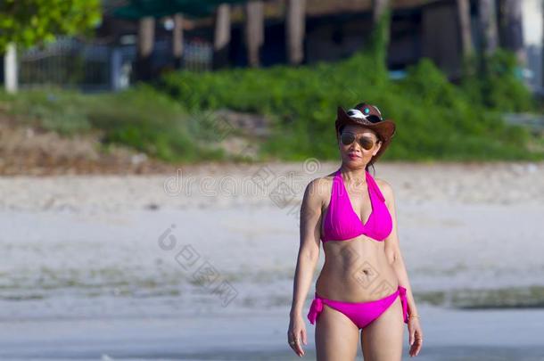 女人身体大大地给看比基尼式游泳衣粉红色的向海滩
