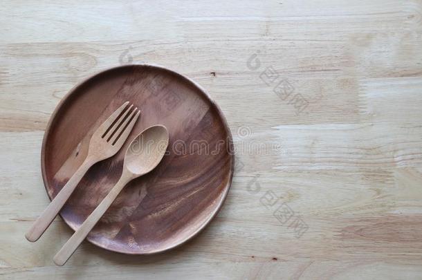 木制的碗和勺和餐叉向木制的背景