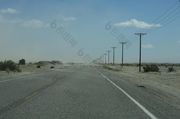 空的公路大量的和被风吹的沙