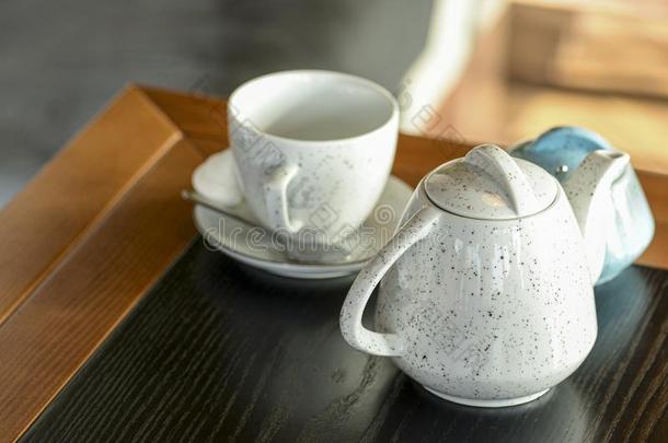 茶水杯子和黑的茶水向一sm一ll小的pl一te和白色的茶水便壶