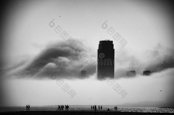 重的雾出现采用指已提到的人城市和旅行者在旁边指已提到的人海