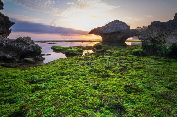 绿松石水和岩石形成在青草海滩,日惹