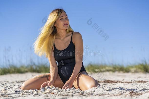 美丽的比基尼式游泳衣模型使摆姿势采用一海滩环境