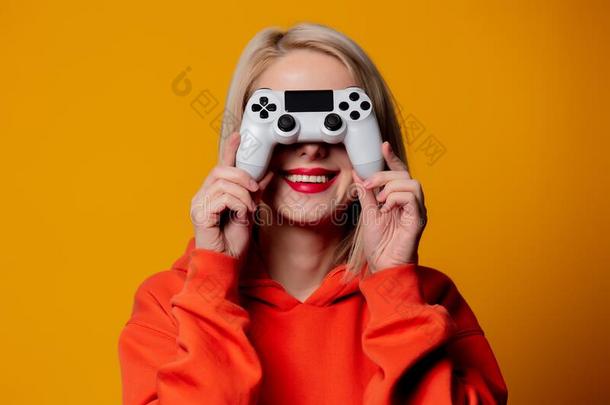 电脑游戏玩家女孩和白色的游戏手柄向黄色的背景