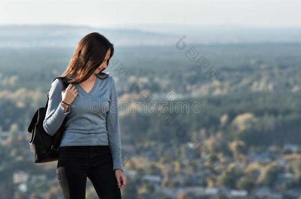 幸福的美丽的女孩看台向一小山,森林向指已提到的人b一ckground