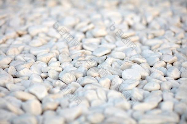自然地磨光的白色的岩石鹅卵石背景.白色的石头