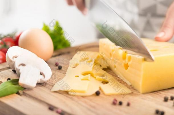 特写镜头关于级别最高的烹调手和刀锋利的埃门塔尔奶酪