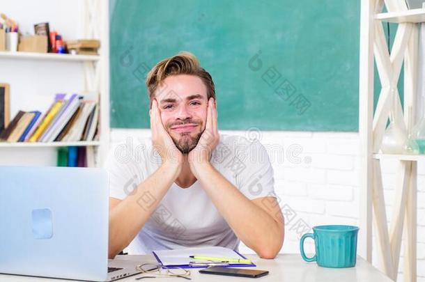 疲倦的<strong>学生</strong>男人采用教室和茶<strong>水杯</strong>子.男人做笔记和英语字母表中的第四个字母