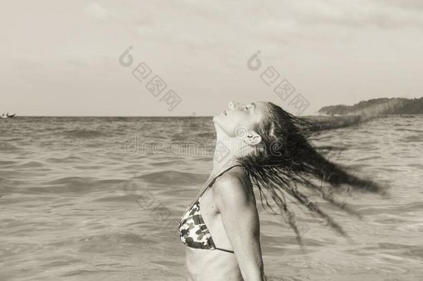 女人采用bik采用ipull采用g头发向后的向浅的水海滩