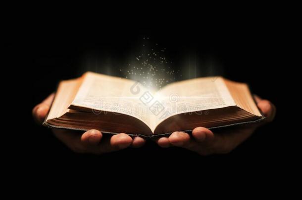 男人保存神圣的圣经书向黑的背景.