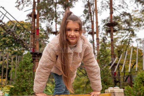 年幼的女孩演奏快乐地和攀登的在森林公园佩格鲁恩