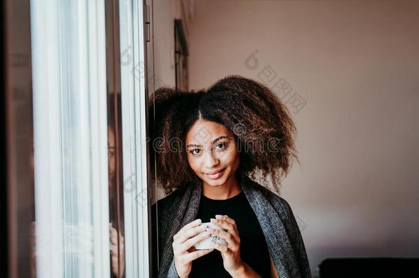 肖像关于美丽的非洲式发型美国人年幼的女人在旁边指已提到的人窗int.引人注意